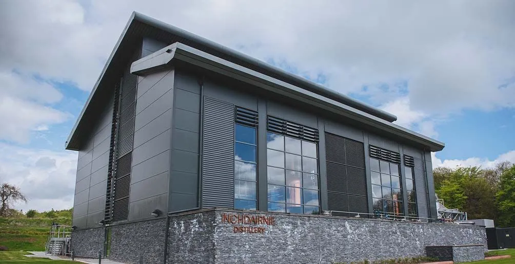 Overview on the exterior of InchDairnie's mordern still house with windows reflecting the blue sky