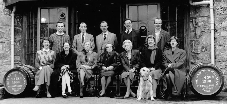 Ein Schwarz-Weiß-Foto der Familie Grant im Jahr 1986 vor dem Gebäude