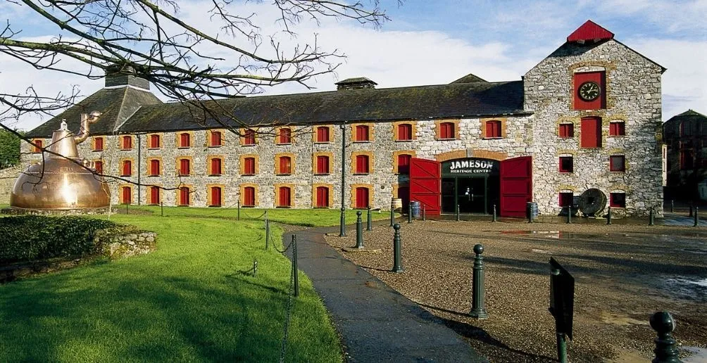 Front entrance of Jameson Distillery surrounded by green grass on a sunny day