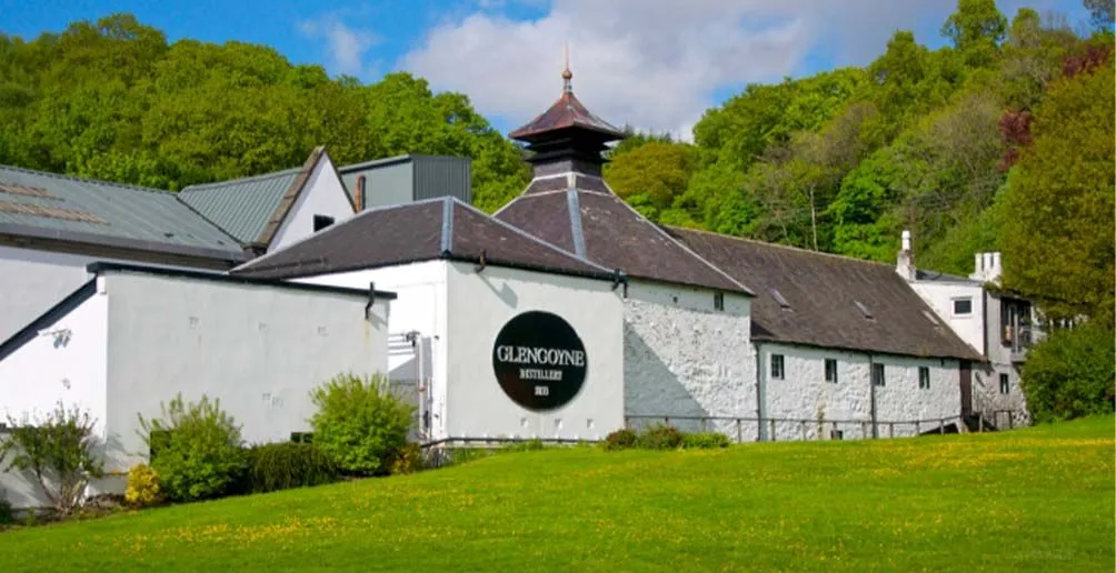 Glengoye distillery with white walls and a pagoda roof surrounded by green nature