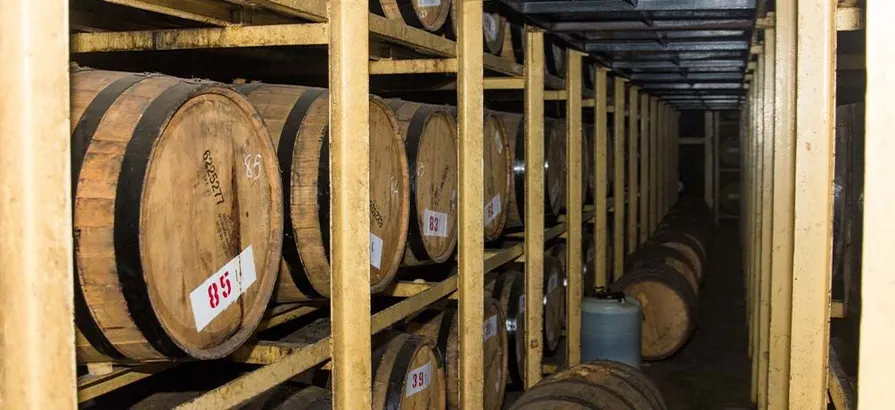 Wooden shelves full of casks stacked in Amrut's warehouse