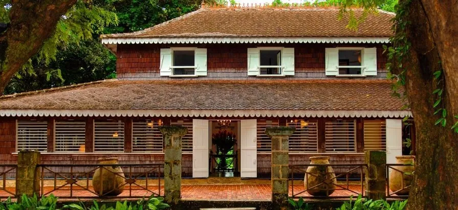 Habitation Clement mansion with brown red walls and open windows surrounded by green nature