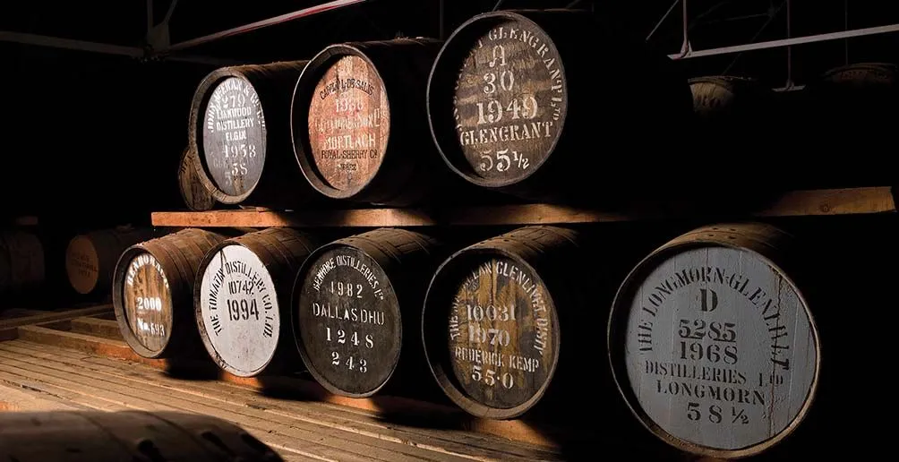 Whisky from different brands matured in casks stack on shelf in Gordon and Macphail's warehouse