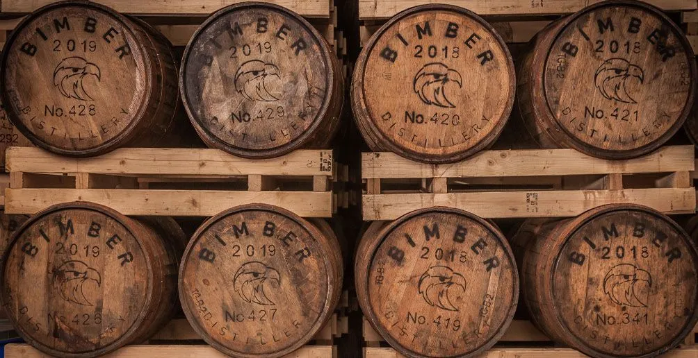 Numbered casks with Bimber logo stacked in two rows in shelves