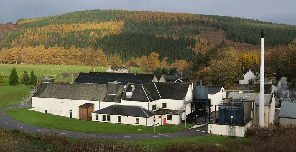 Photo of Cragganmore distillery located at the foot of a hill taken in early autumn