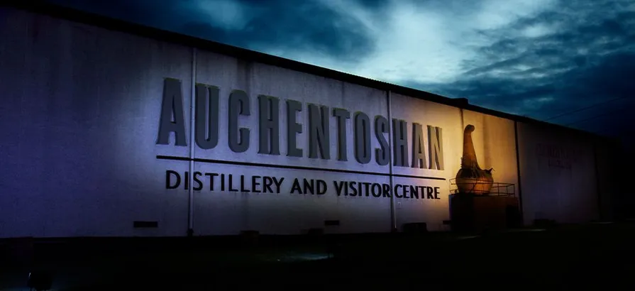 Exterior view of Auchentoshan distillery's visitor centre at night