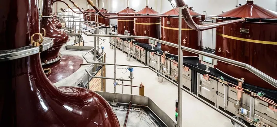 Row of huge condensers located on the left of the picture with lyne arms connected to the pot stills