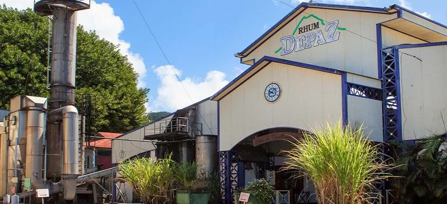 Exterior of Depaz Rhum distillery with its logo on the front wall with blue sky on the background