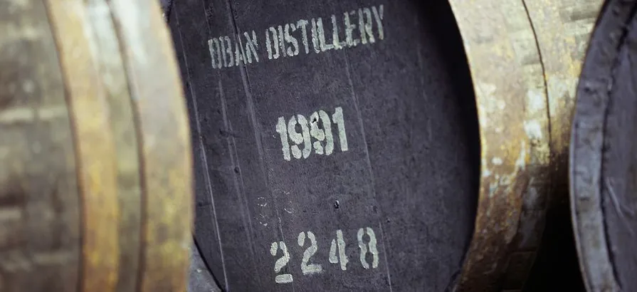 Close view on a numbered cask with the distillery's name and distilling date painted on the lid