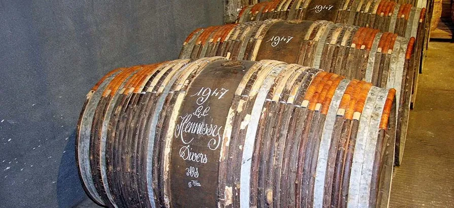 Fässer mit dem Jahr der Reifung, dem Namen der Marke Hennessy und der Art des Cognacs in Kreide auf ihrem Körper