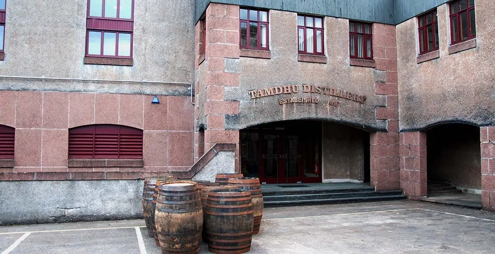 Casks waiting to be filled in front of Tamdhu distillery building made of bricks