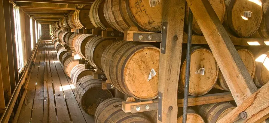 Sunlight through the windows landing on barrels stacked on shelves in Jack Daniel's wooden warehouse