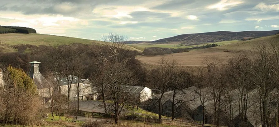 Bird view on the whole Mortlach distillery area located among fields and trees going bald in autumn