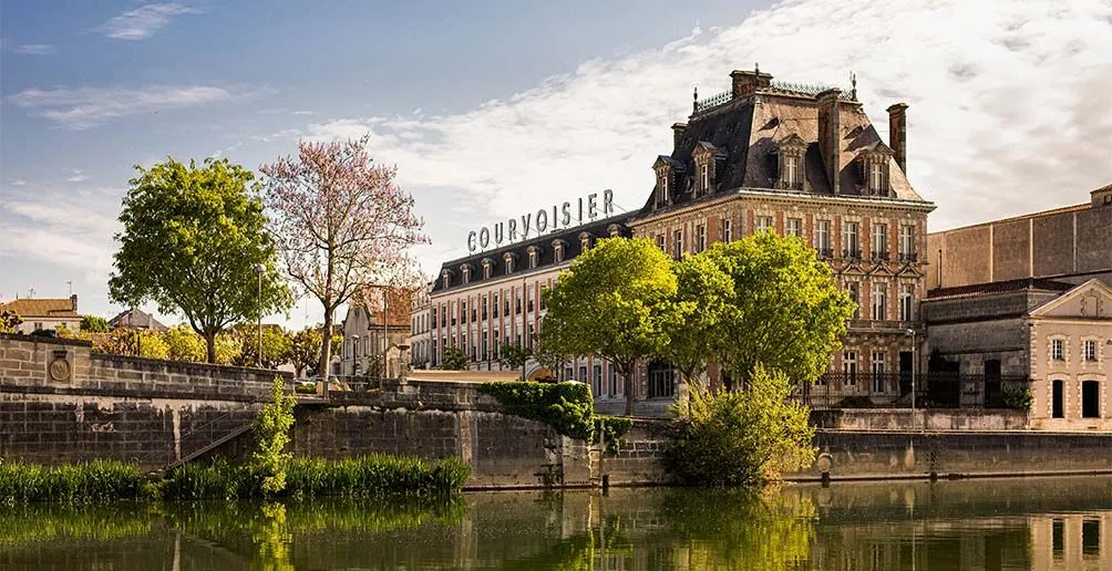 Das Courvoisier-Gebäude mit seinem Namen auf dem Dach vom anderen Flussufer aus gesehen