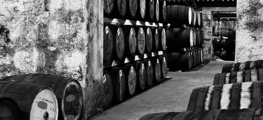 Black and white photo of casks stacked neatly in shekves in Glenglassaugh's warehouse