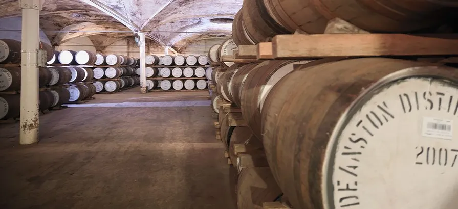 Casks inside of the Deanston distillery stacked in rows on the shelves