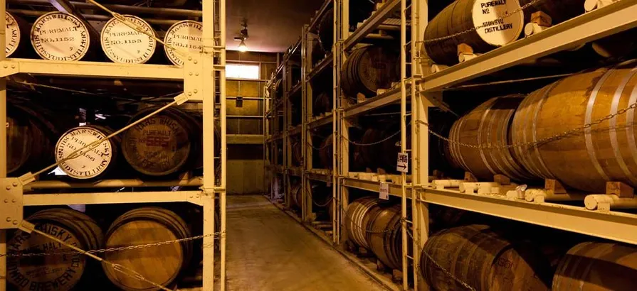 Casks stacked in metal shelves in Shinshu's warehouse