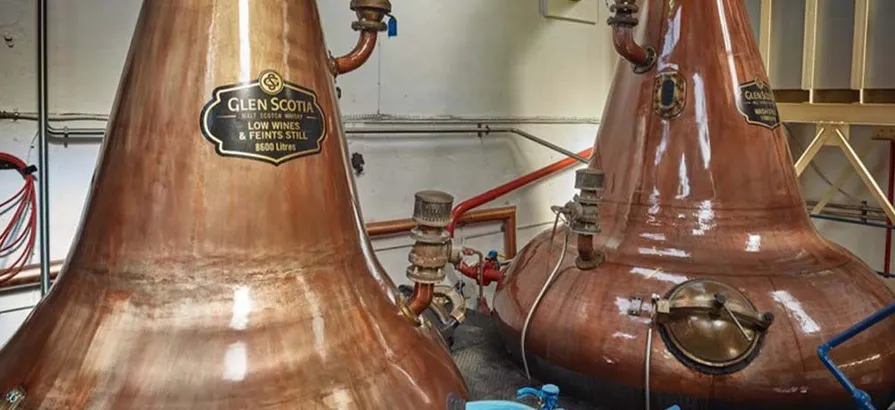 Close view on two copper pot stills with different labels