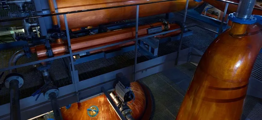 A lyne arm of a copper pot still in Macduff's still house viewed from above