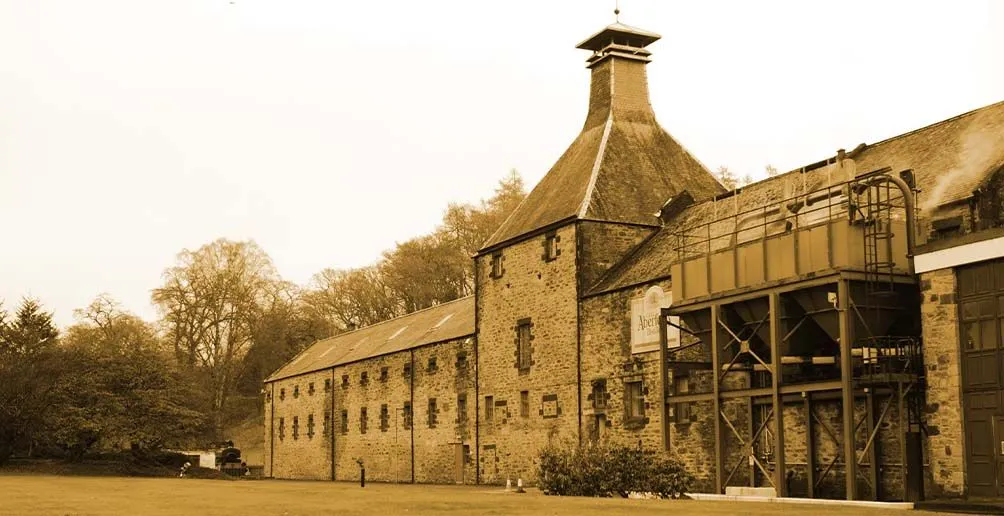 Brick building of Aberfeldy distillery with steam coiling out during work hours