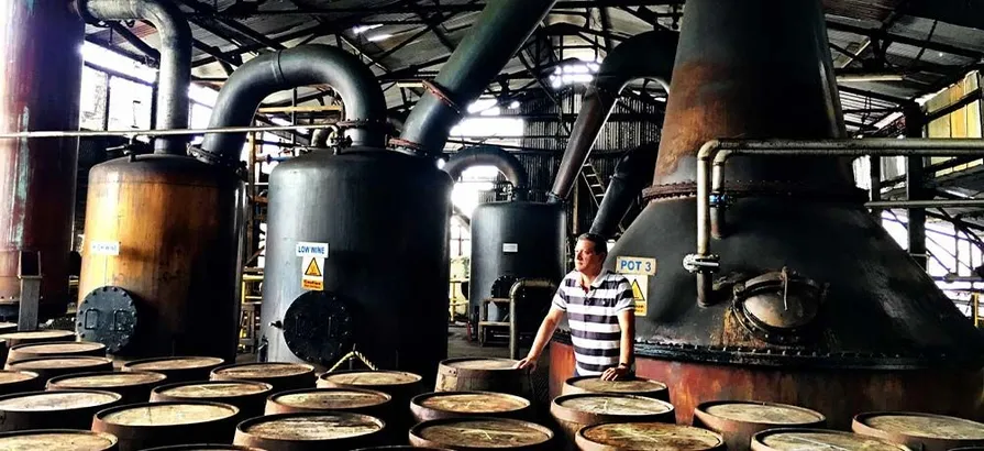 Casks waiting to be filled next to pot stills inside of Hampden's still house